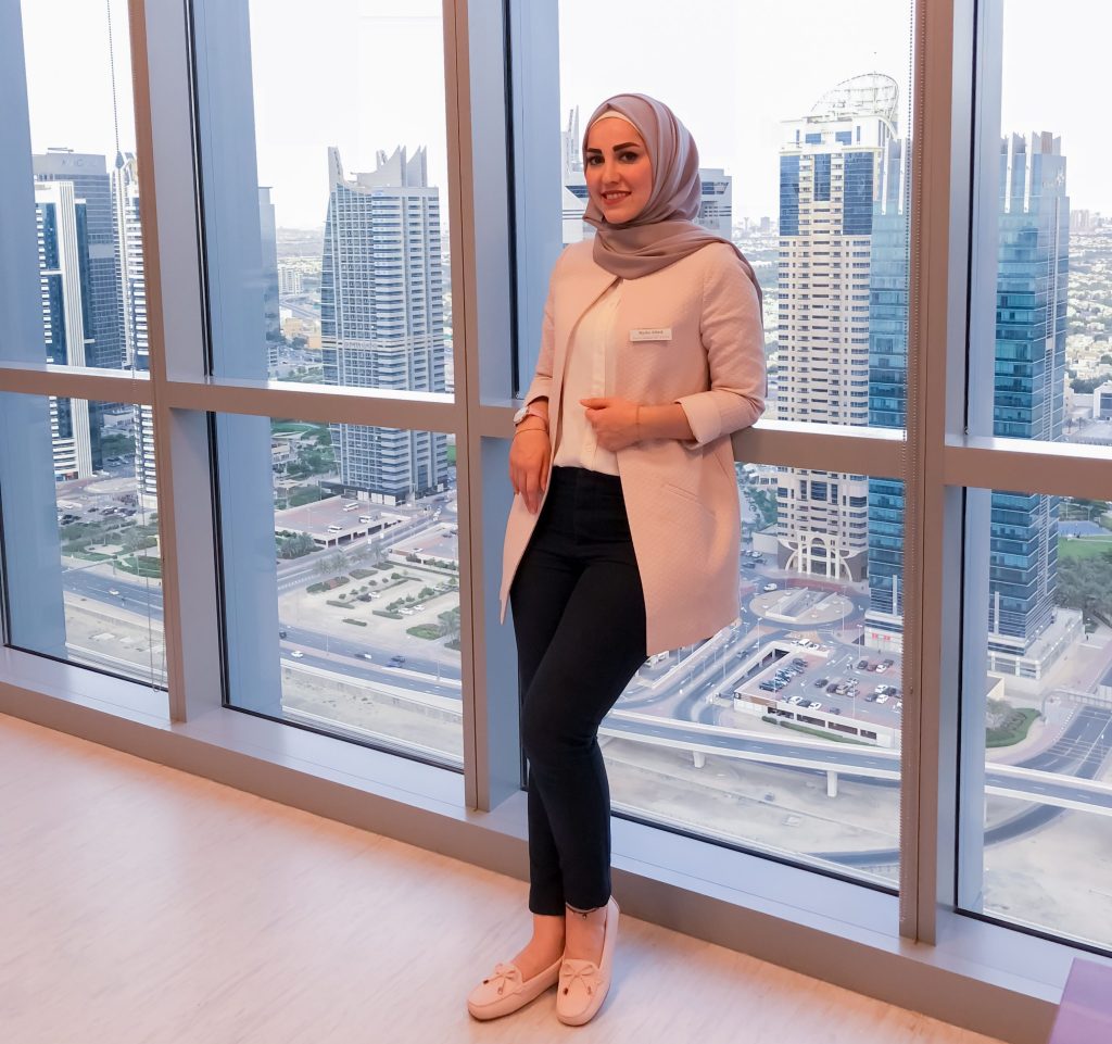 Femme élégante au bureau qui montre qu'on peut parfaitement combiner la mode hijab et travail.