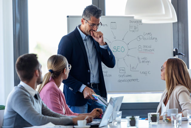 personnes en réunion travaillant dans une agence de marketing ciblant le référencement seo