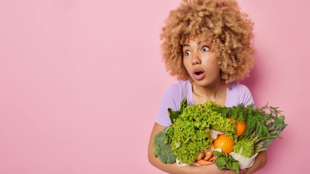 Comment rajeunir la peau qui vieillit? Femme qui tient des fruits et légume démontrant que l'alimentation est important.