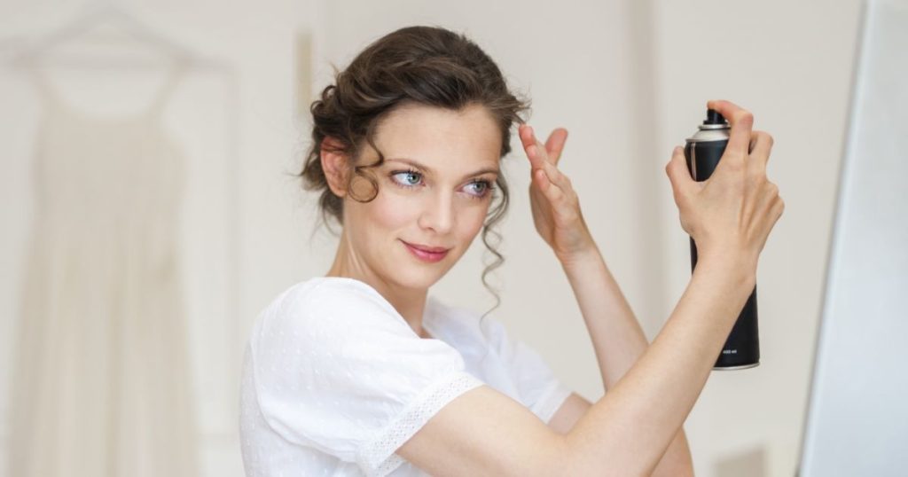 Femme qui utilise son meilleur shampoing sec en spray