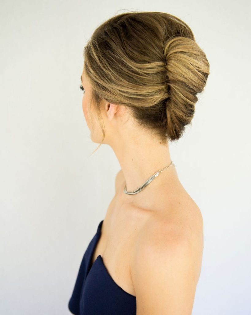 The French twist is one of the most iconic claw clip hairstyles to create with a hair clip. To begin, it is necessary to have dry and brushed hair. The first step is to gather your hair at the back into a low ponytail. After that, twist your hair upwards with your fingers towards the top of your head. Keep your hand on it and, with the other hand, place the claw clip at the base of your head while closing it so that your hair is secured inside. Once this step is completed, you can use hairpins to fix any strands that refuse to cooperate and add hairspray for a more chic, long-lasting look if desired.