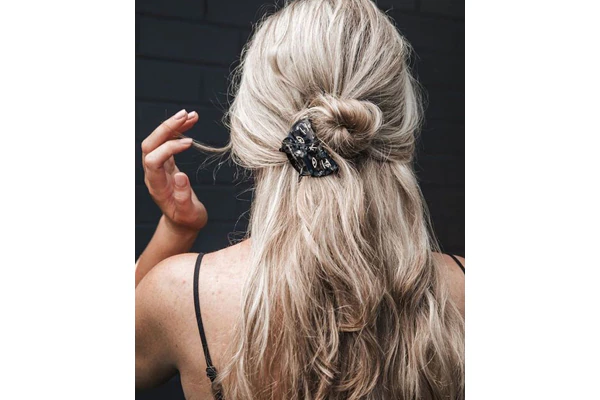 The Half Bun is a hairstyle that you can make to impress your friends with minimal effort. To begin, separate your hair into two sections. For the top section, take a small amount of hair and leave the rest for the bottom section. Next, make a ponytail with the top section and twist it into a loose loop. Than, secure the hair with the claw clip. For a more casual look, you can gently pull some strands.