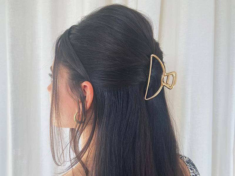 The Half up Half down is perfect for when you're in a hurry but still want to look put-together. To start off, separate your hair into two sections, a small section with the hair above your head and the rest resting on your shoulders. Fix the top section with your claw clip. As a bonus, you can add hair accessories and hairspray to perfect your look.