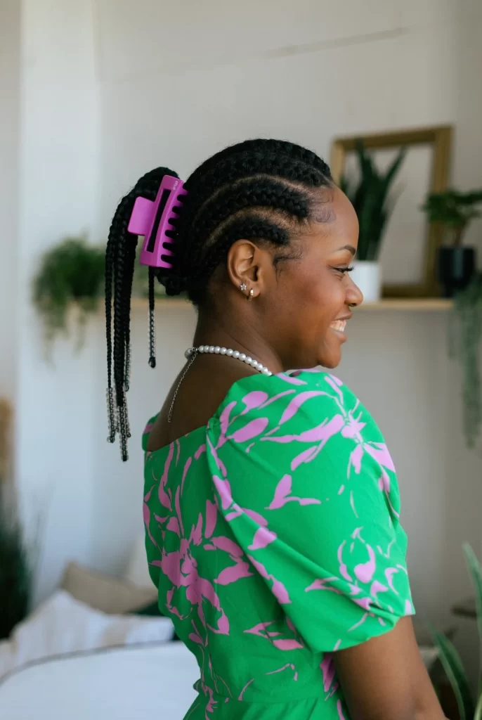 
A woman is wearing a pink fuchsia PixieWoo hair clip in her black hair. The claw clip is holding all of her hair.