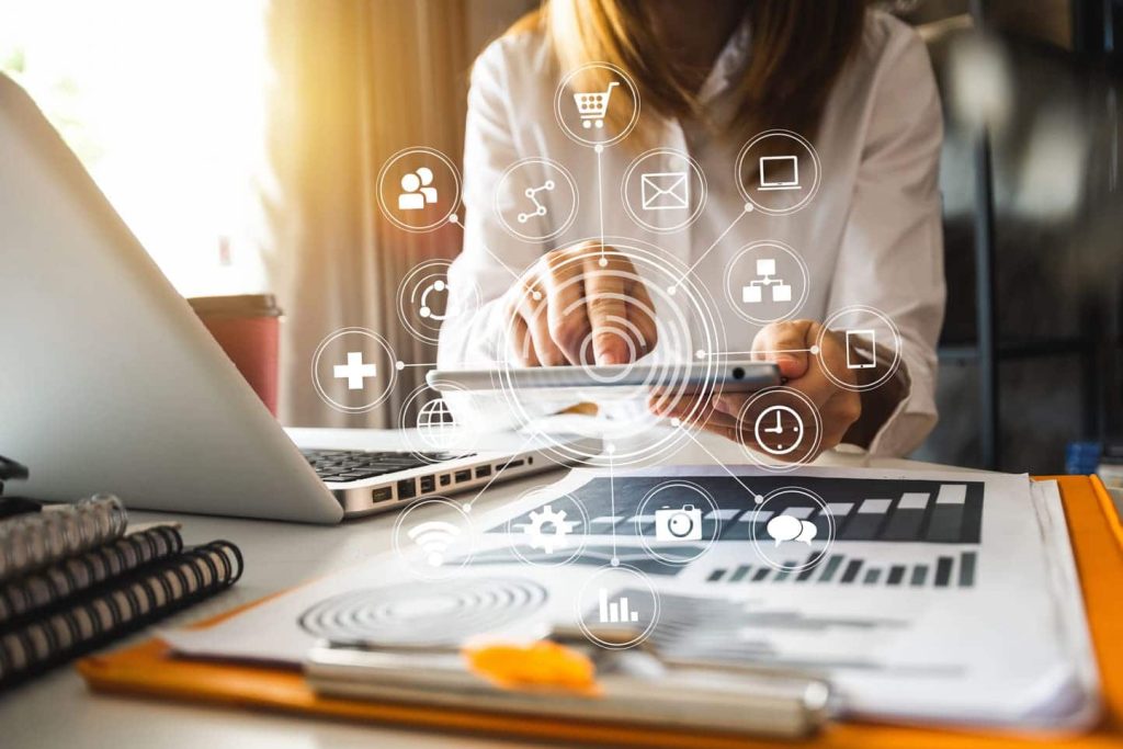 femme qui pointe le doigt vers un ecran et tout les symboles du marketing digital et reseaux sociaux font apparence sur l'image